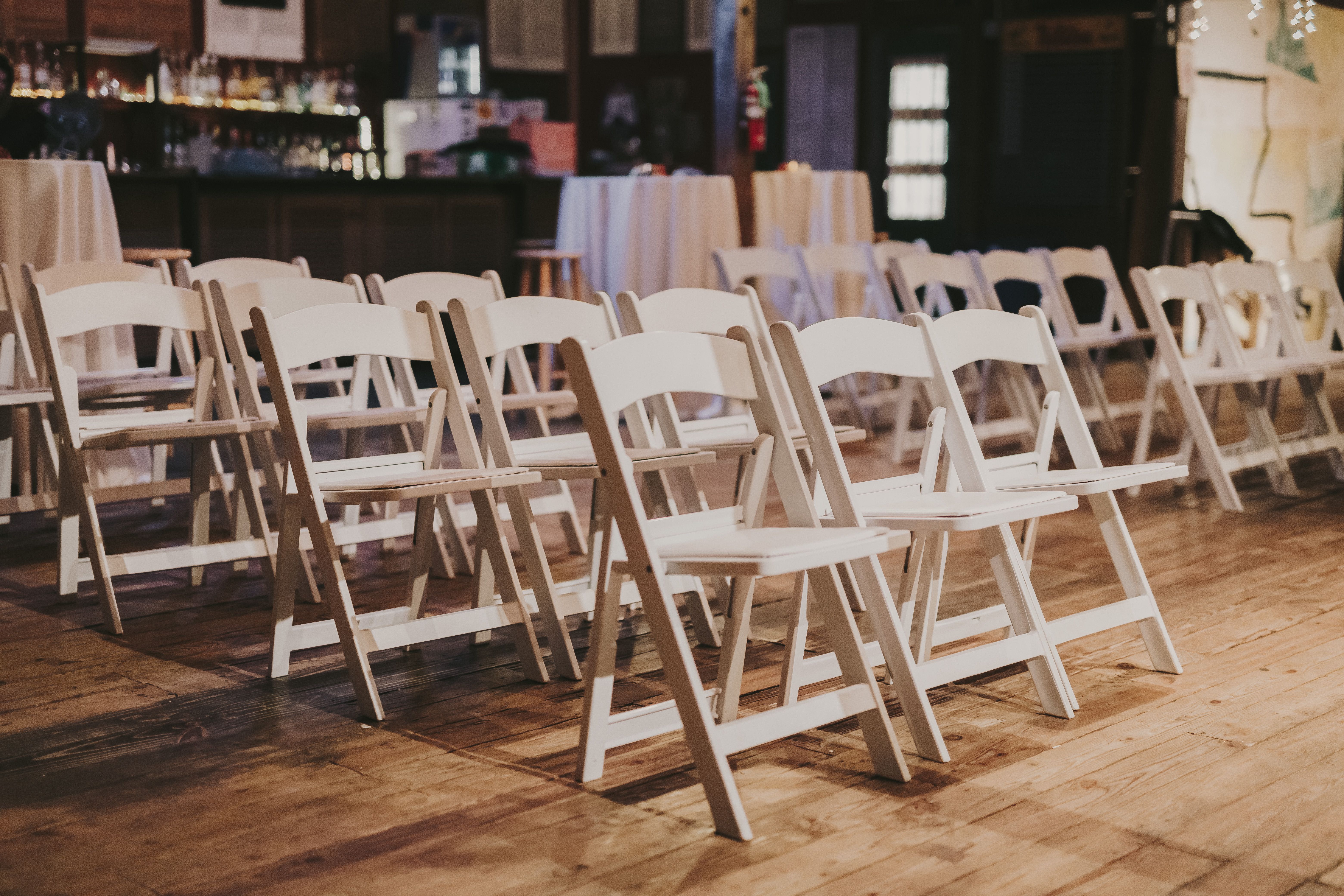 White folding chairs set up inside a rustic barn event venue